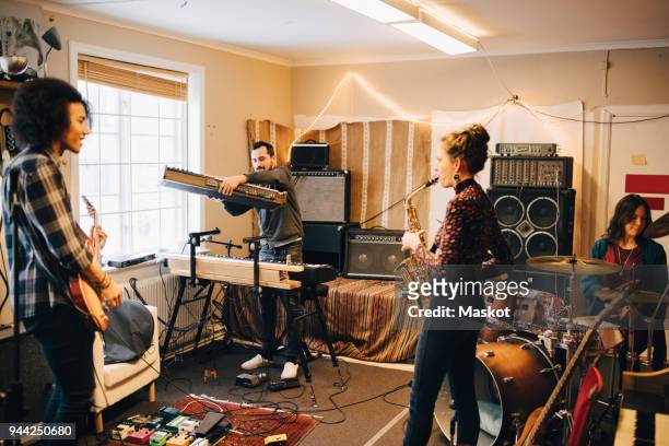 male and female friends playing various instruments at recording studio - rehearsal bildbanksfoton och bilder