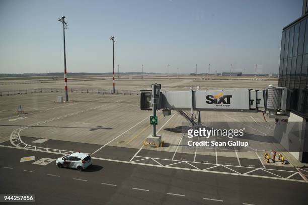 Car from a security company drives past a passenger ramp at the BER Willy Brandt Berlin Brandenburg International Airport on April 10, 2018 in...