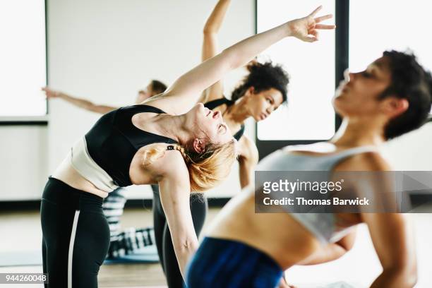 Sweating women in hot yoga class in fitness studio