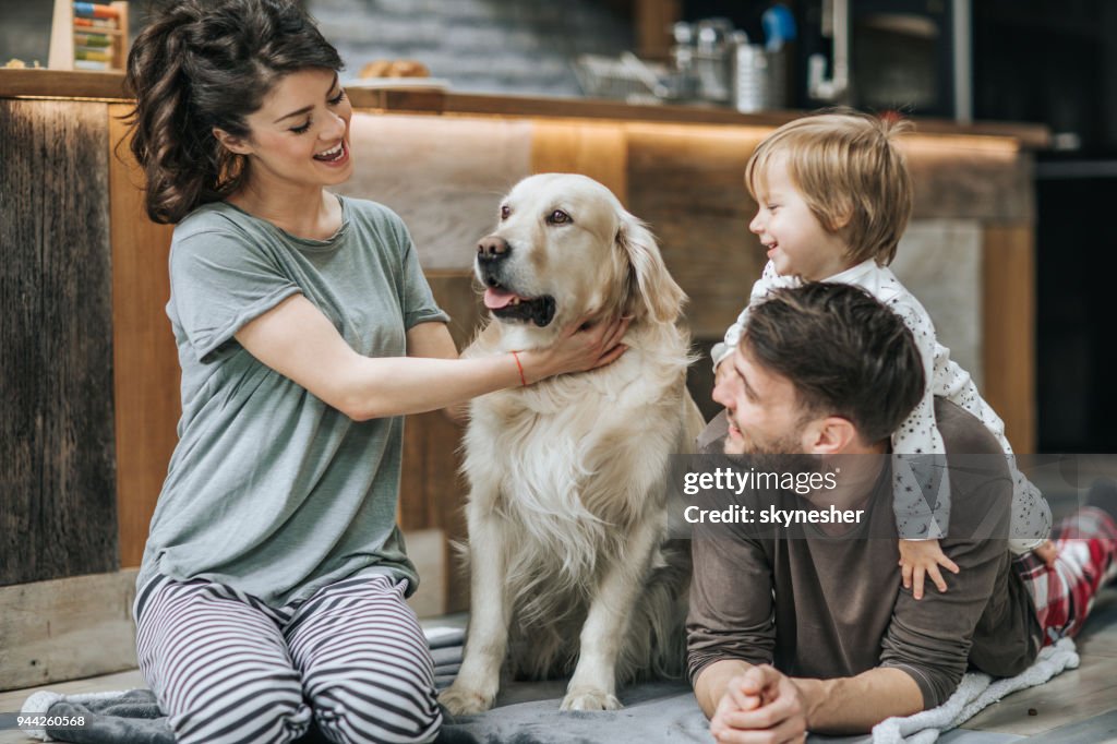 Gelukkige familie ontspannen met hun hond thuis.