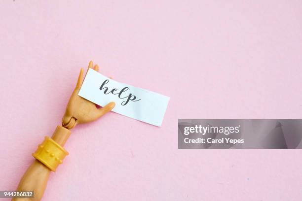 doll hand in white with " help" message on paper - mannequin arm stock pictures, royalty-free photos & images