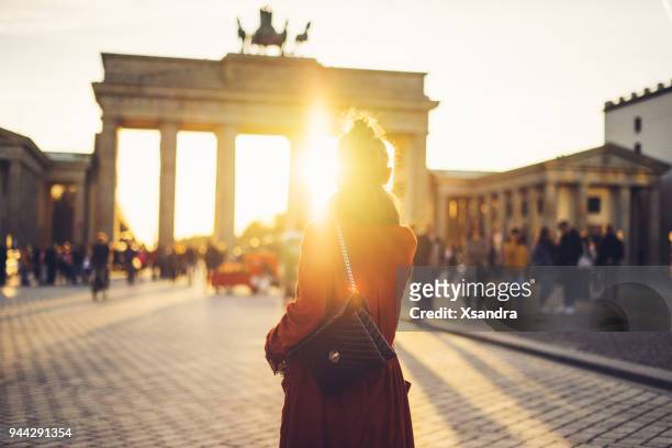junge frau vor dem brandenburger tor in berlin, deutschland - berlin stock-fotos und bilder