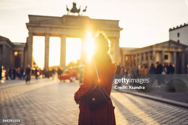 young woman in front of brandenburger tor in berlin, germany - porta de brandemburgo imagens e fotografias de stock