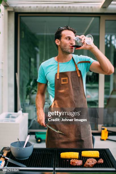 man barbecuing in garden - schürze stock-fotos und bilder