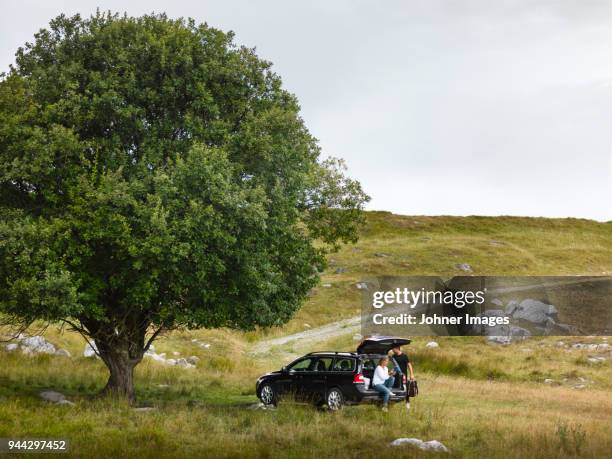 couple sitting near car - car scandinavia stock pictures, royalty-free photos & images