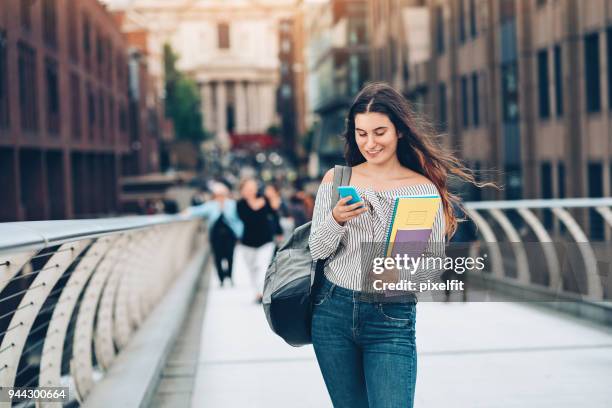 university student with smart phone and textbooks - college student stock pictures, royalty-free photos & images