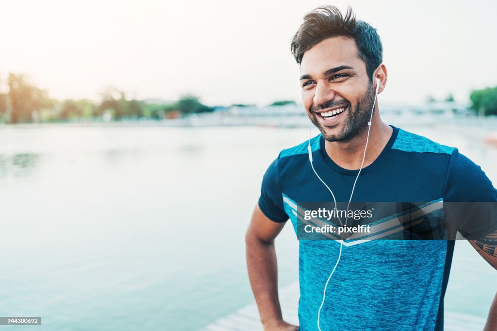Cheerful young athlete outdoors by the river