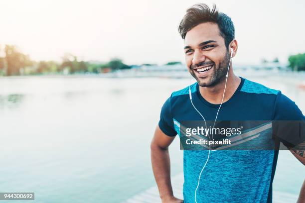 cheerful young athlete outdoors by the river - jogging stock pictures, royalty-free photos & images