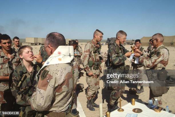 View of American soldiers as they receive communion from military chaplains during the Gulf War, Iraq, 1991.