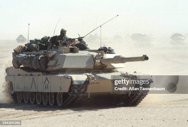 View of an American M1A1 Abrams tank as it crosses the desert during the Gulf War, Iraq, 1991. Other tanks are visible in the background.