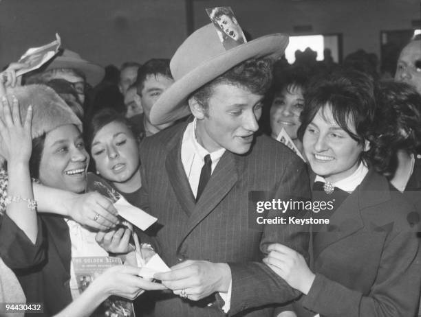 French singer and actor Johnny Hallyday surrounded by fans at Orly Airport in Paris, upon his return from a tour of the United States, 7th March 1962.