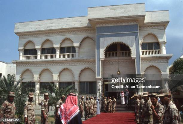 View of Kuwaiti soldiers as they line up to form an honor guard on either side of a red carpet outside an unidentified building, Kuwait, 1991. They...
