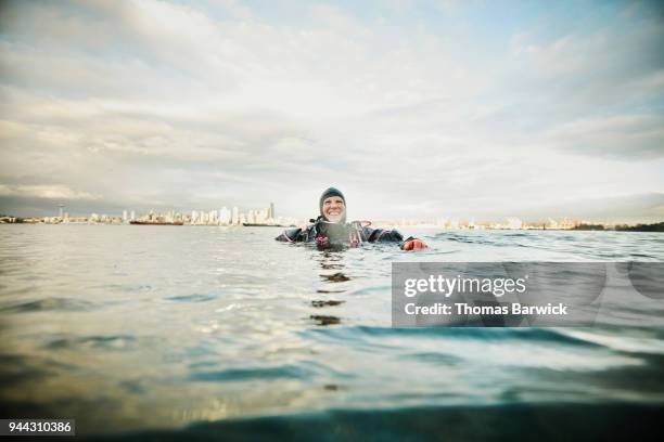 laughing female diver at surface of water after open water dive - dive adventure foto e immagini stock