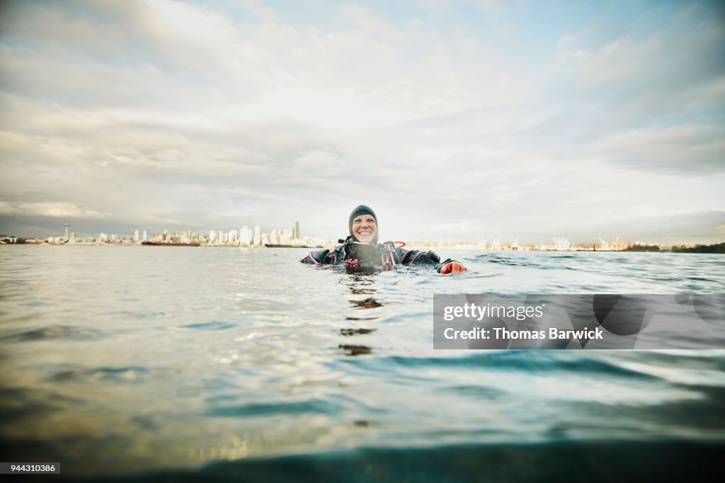 Laughing female diver at surface of water after open water dive