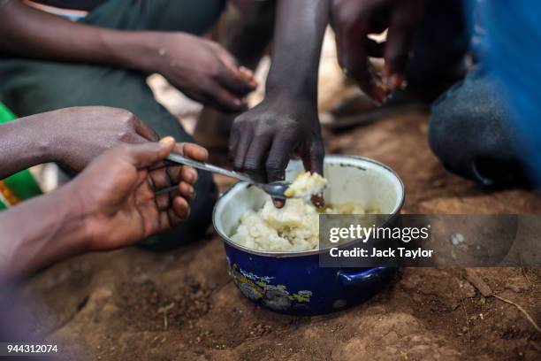 Refugees from the Democratic Republic of Congo eat a lunch consisting of maize and peas from the World Food Programme in the Kagoma reception centre...