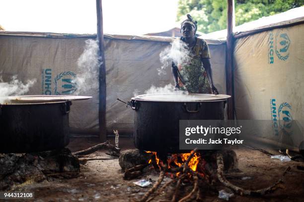 Volunteer helps cook food from the World Food Programme for refugees from the Democratic Republic of Congo in the Kagoma reception centre within the...