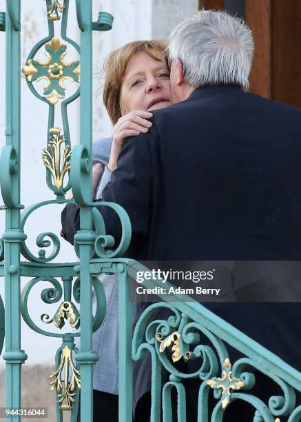 German Federal Chancellor Angela Merkel greets European Commission President Jean-Claude Juncker at a government retreat at Schloss Meseberg on April...