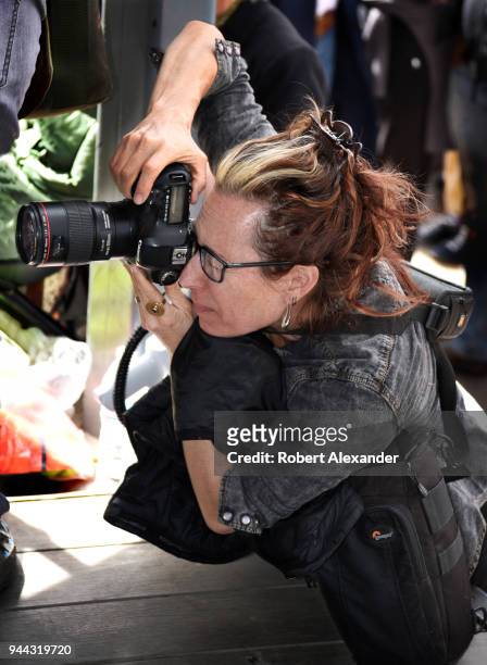 Photographer using a Canon camera takes photographs at a rally in Santa Fe, New Mexico.
