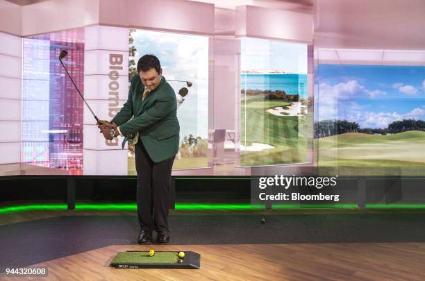 Professional golfer Patrick Reed swings a gold club during a Bloomberg Television interview in New York, U.S., on Tuesday, April 10, 2018. Reed...