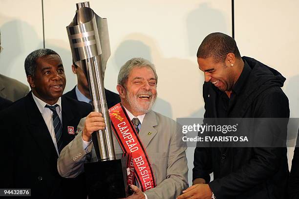 Brazil's President Luiz Inacio Lula da Silva holds the trophy next to Flamengo's striker Adriano and the team's head coach Andrade in Brasilia, on...