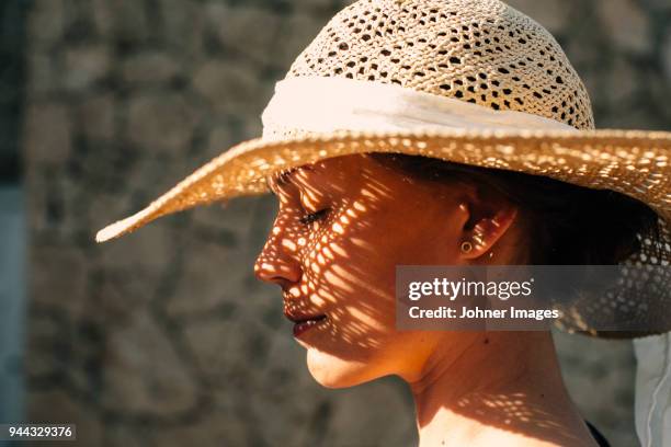 woman wearing straw hat - sonnenhut stock-fotos und bilder