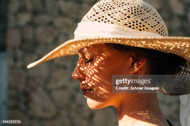 woman wearing straw hat - zonnehoed stockfoto's en -beelden