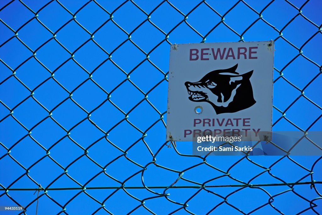 Private property warning sign on fence