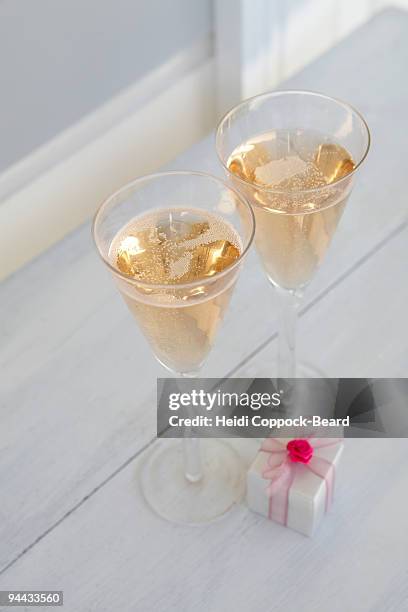 two glasses of champagne with a present - heidi coppock beard stock-fotos und bilder