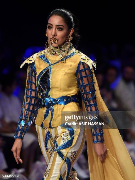 Model presents a creation by Pakistani designer Hassan Riaz on the first day of the Fashion Pakistan Week in Karachi on April 10, 2018. / AFP PHOTO /...