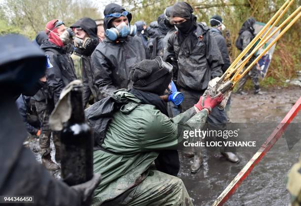 Protester uses a catapult as clashes erupt during a police operation to raze the decade-old camp known as ZAD at Notre-Dame-des-Landes, near the...