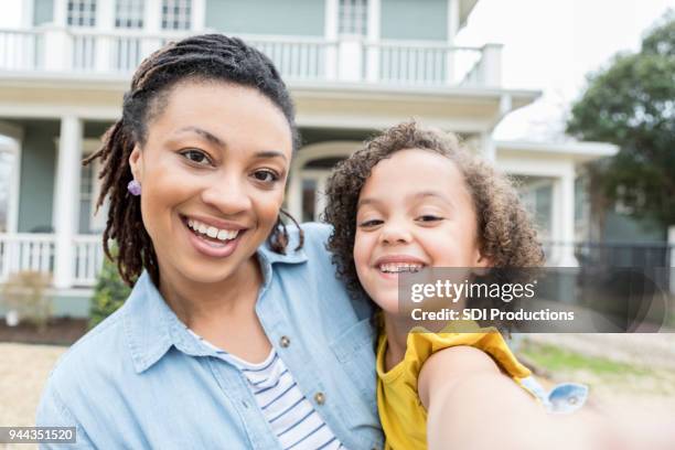 mother and young daughter take selfie in front yard - new home pov stock pictures, royalty-free photos & images