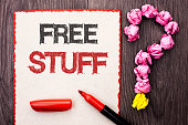 Writing note showing  Free Stuff. Business photo showcasing Complementary Free of Cost Chargeless Gratis Costless Unpaid written on Cardboard Piece With Marker wooden background Question Mark.