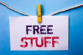 Text sign showing Free Stuff. Conceptual photo Complementary Free of Cost Chargeless Gratis Costless Unpaid written on White Note Paper hanging with rope on the plain background Clip.