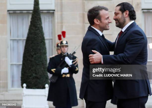 French President Emmanuel Macron greets Lebanese Prime Minister Saad Hariri as he arrives for an official dinner at The Elysee Palace in Paris on...