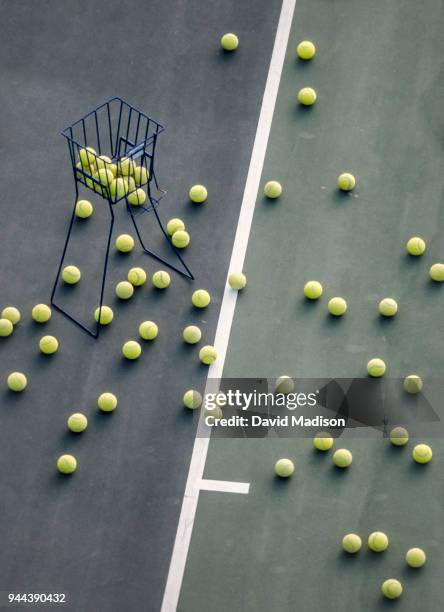 tennis practice balls and basket on court - tennis ball stock pictures, royalty-free photos & images
