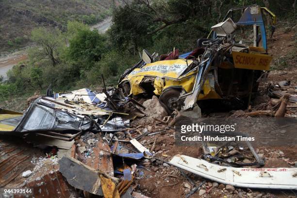The mangled remains of a school bus are visible after it fell into a gorge near Gurchal village, near Nurpur on April 10, 2018 in Kangra, India....