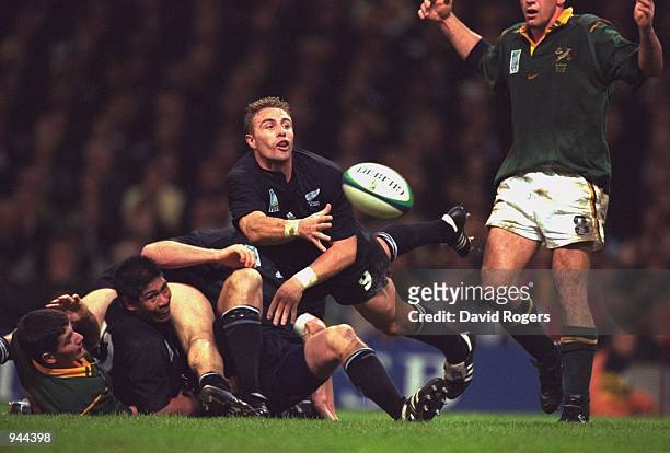 Justin Marshall of New Zealand gets his pass away during the Rugby Union World Cup 1999 match against South Africa played at the Millennium Stadium,...