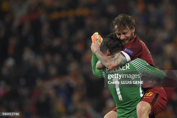 Roma's Italian midfielder Daniele De Rossi and AS Roma's Brazilian goalkeeper Alisson Becker celebrate after winning the UEFA Champions League...