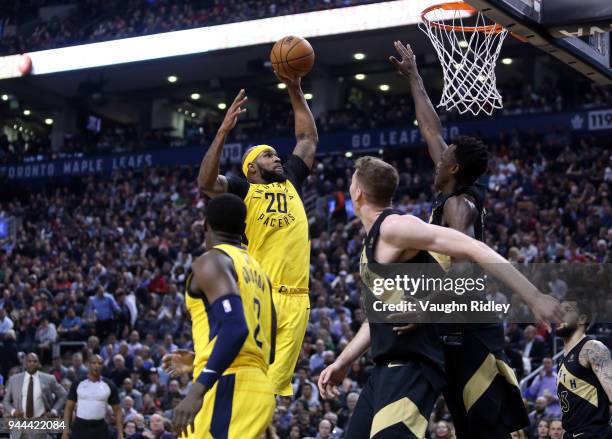 Trevor Booker of the Indiana Pacers shoots the ball as Pascal Siakam and Jakob Poeltl of the Toronto Raptors defend during the first half of an NBA...