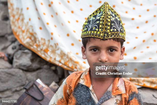 Young boy who is wearing an embroidered Taqiyah, a traditional oriental headgear on March 28, 2013 in Bijapur, India. Around 50,000 people are living...