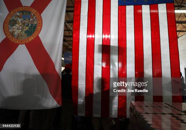 Supporters cast their shadow on the flag as they listen to Florida Governor Rick Scott speak during his Senate campaign rally at the Interstate...