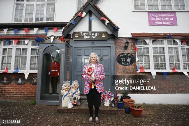 Royal fan Margaret Tyler poses for a photograph outside her house in north London on April 4, 2018. - Festooned with bunting and guarded by a...