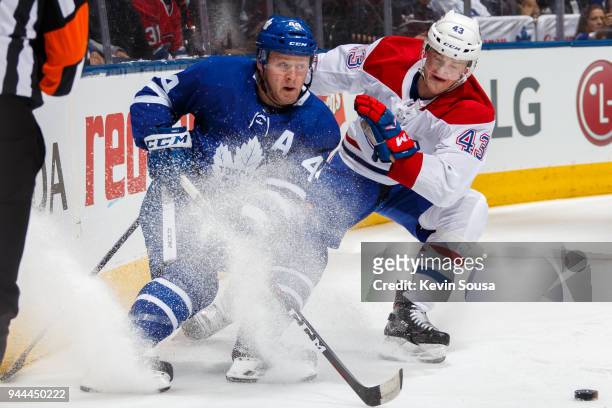 Morgan Rielly of the Toronto Maple Leafs battles for the puck against Daniel Carr of the Montreal Canadiens during the first period at the Air Canada...