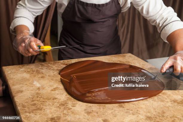 crop pastry man cooling chocolate on marble - angry rich guy stock-fotos und bilder