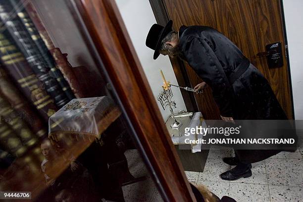 An ultra Orthodox Jewish man lights the fourth candle during a ceremony for the Jewish festival of Hanukkah in Bnei Brak, near Tel Aviv, on December...