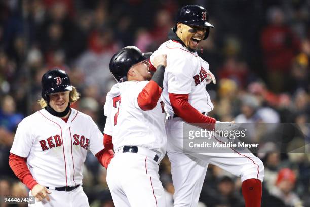 Mookie Betts of the Boston Red Sox celebrates with Brock Holt and Christian Vazquez after hitting a grand slam during the sixth inning against the...