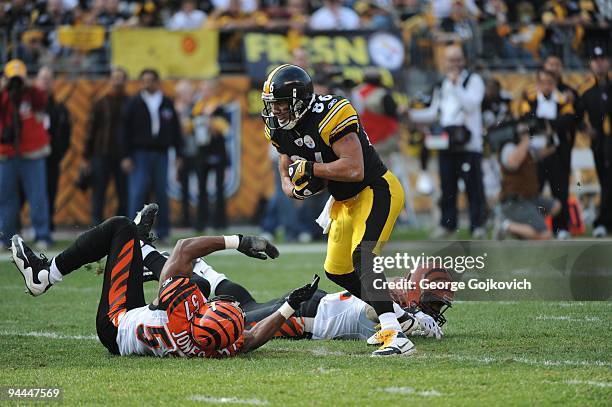 Wide receiver Hines Ward of the Pittsburgh Steelers runs with the football after catching a pass against linebacker Dhani Jones and safety Chinedum...