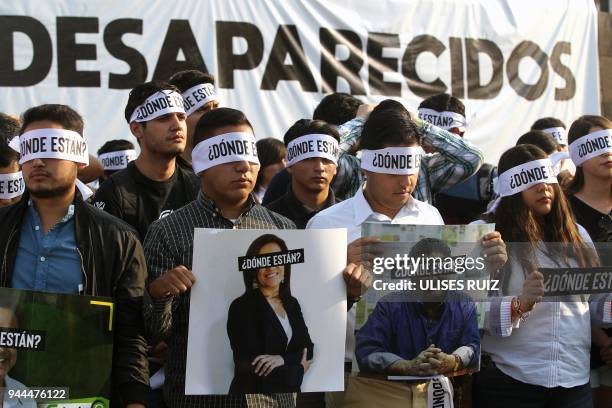 Relatives and friends of three students of the University of Audiovisual Media who are missing since March 19 hold portraits of presidential...