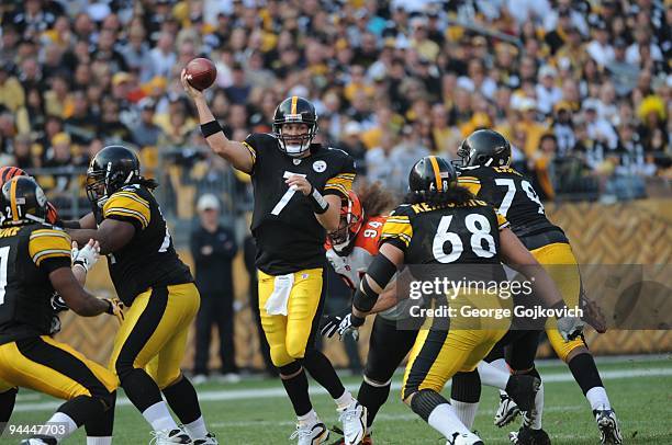 Quarterback Ben Roethlisberger of the Pittsburgh Steelers passes while under pressure from defensive lineman Domato Peko of the Cincinnati Bengals as...