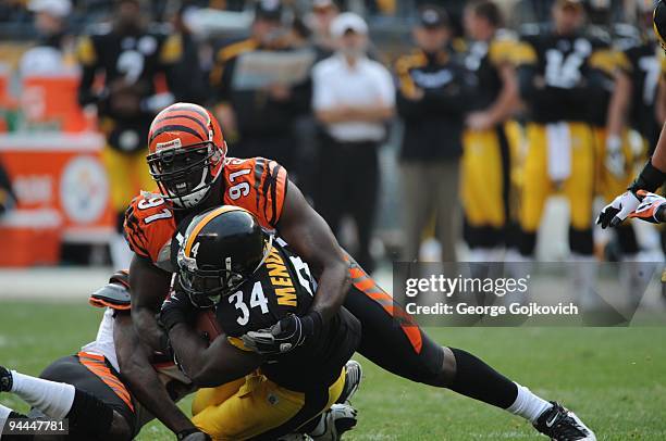 Defensive lineman Robert Geathers of the Cincinnati Bengals tackles running back Rashard Mendenhall of the Pittsburgh Steelers during a game at Heinz...